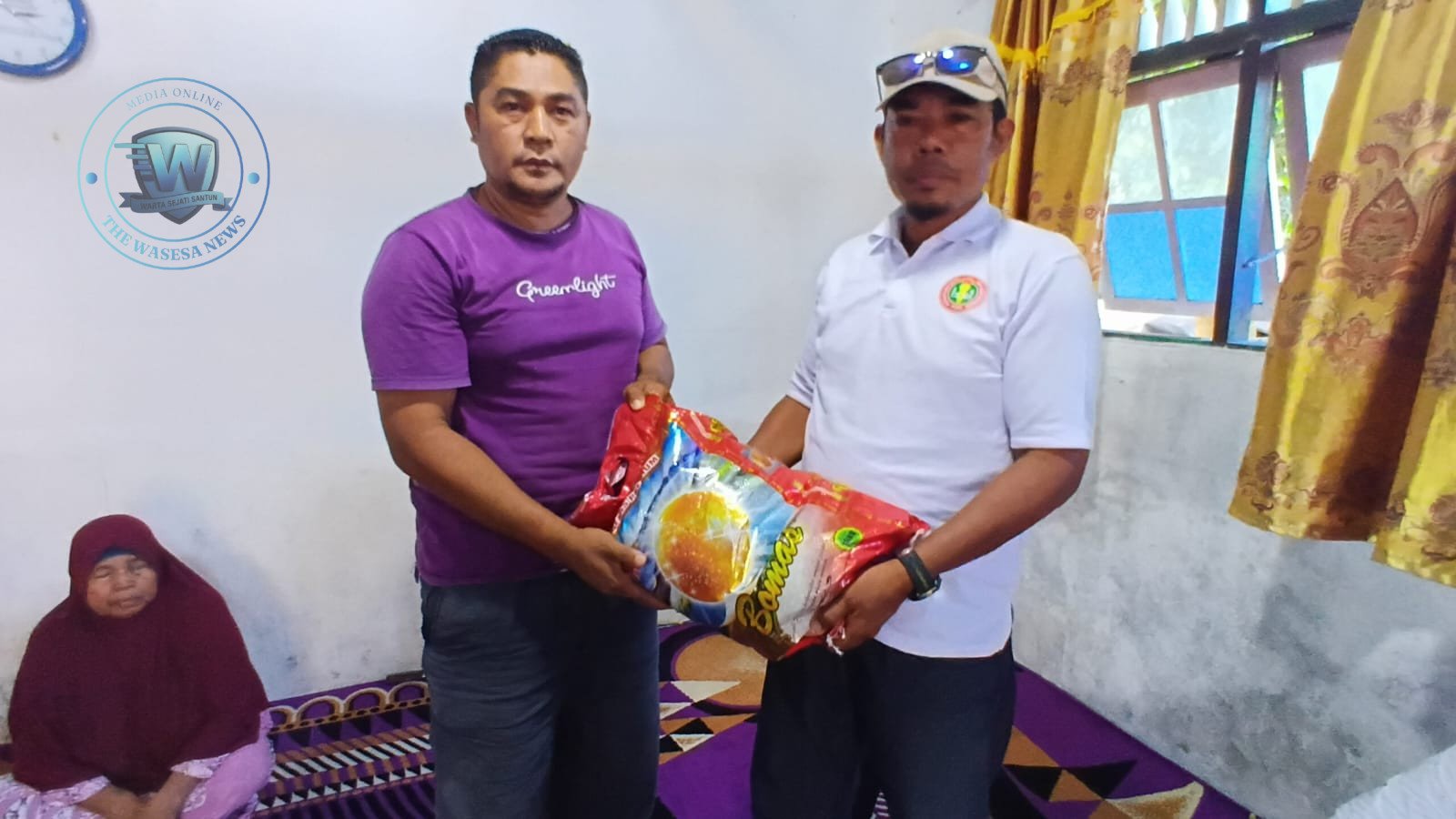 Ketua PGRI Halteng Sahril Taher saat menyerahkan bantuan sembako kepada keluarga korban serangan OTK di rumah duka Desa Banemo. - thewasesanews.com