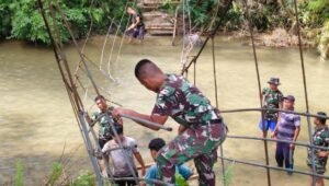 Personel Kodim 0212/TS bersama warga membangun jembatan gantung sepanjang 33 meter di Desa Parupuk Julu. - thewasesanews.com