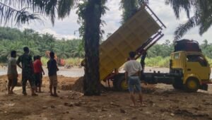 Personel Koramil 09/Sosa Kodim 0212/TS bersama warga Desa Parapat melakukan pengecoran pondasi jembatan gantung di Kecamatan Ulu Sosa. - thewasesanews.com