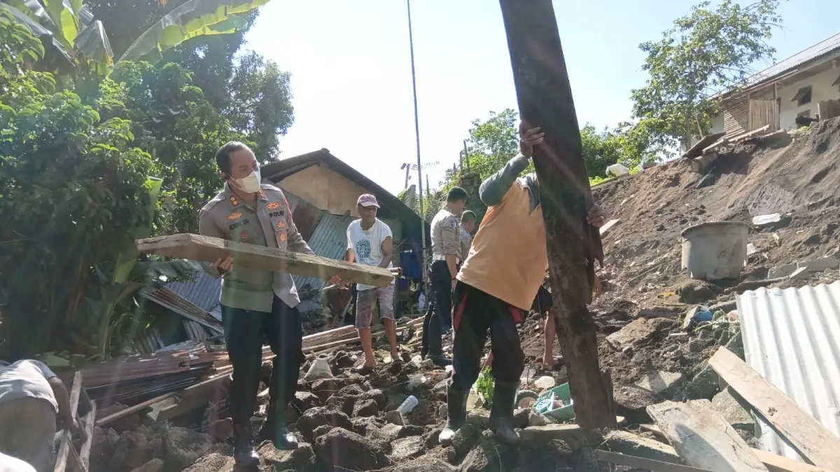 Kapolres Bitung AKBP Albert Zai bersama personel kepolisian membantu membersihkan puing rumah warga yang roboh pasca gempa Magnitudo 7,6. - thewasesanews.com