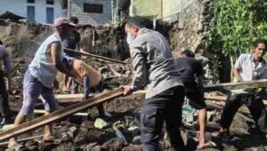 Kapolres Bitung AKBP Albert Zai bersama personel kepolisian membantu membersihkan puing rumah warga yang roboh pasca gempa Magnitudo 7,6. - thewasesanews.com
