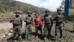 Prajurit Satgas Yonif 521/DY bersama Ibu Sani Siep sedang mencangkul dan menanam bibit di lahan perkebunan Distrik Kurima, Yahukimo. - thewasesanews.com