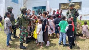 Prajurit Satgas Yonif 521/DY saat membagikan makanan ringan dan memberikan motivasi kepada anak-anak di Distrik Apalapsili, Kabupaten Yalimo. - thewasesanews.com