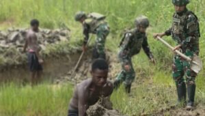 Prajurit Satgas Yonif 521/DY bersama warga Distrik Eragayam bergotong royong membangun kolam ikan budidaya sebagai sarana ketahanan pangan. - thewasesanews.com