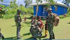 Prajurit Satgas Yonif 521/DY sedang berdialog akrab dengan warga di depan rumah dalam kegiatan Komsos di Distrik Kobakma. - thewasesanews.com