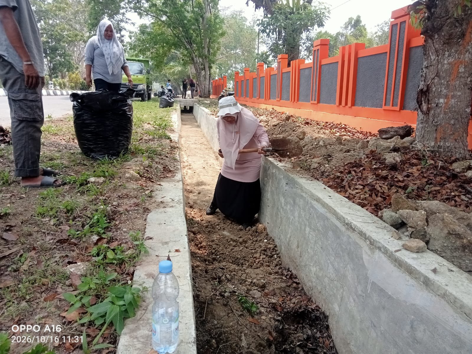 HUT Halteng Ke-36 Kadis DLH Hj Rivani Abdurajak Bersihkan Got. - thewasesanews.com